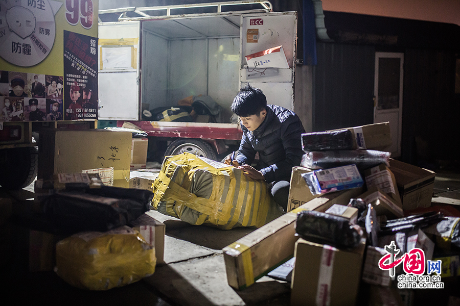 Hou carefully examines the goods before going off duty. [Photo/China.org.cn]