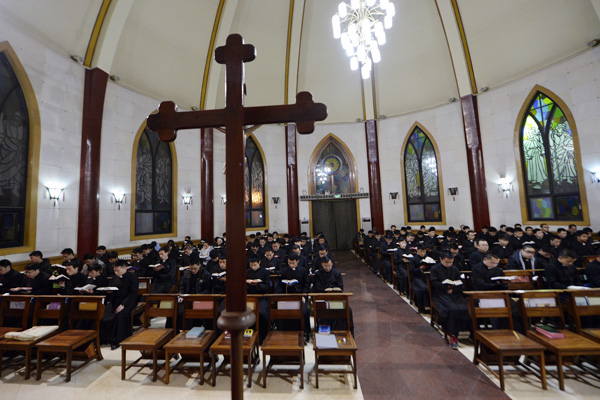 Seminarians read the Bible during evening prayers at the National Seminary of the Catholic Church in Beijing.[Photo by Wei Xiaohao/China Daily] 