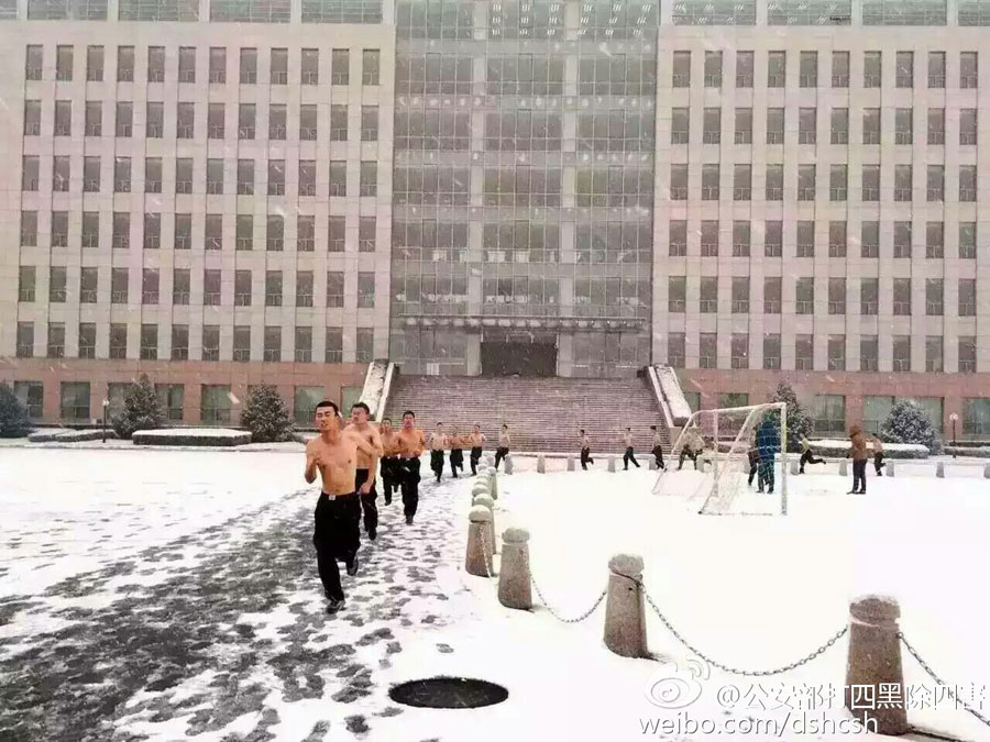 Students from People's Public Security University of China receive training in the snow in Beijing on Nov. 22, 2015. Heavy snowfall hit Beijing on Sunday. [Weibo.com]