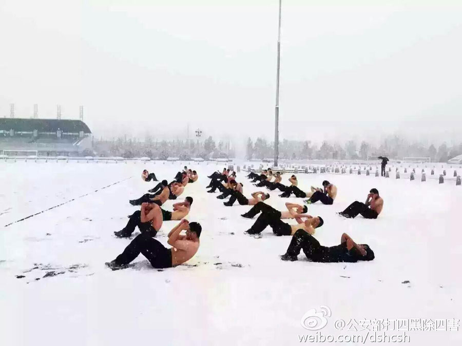 Students from People's Public Security University of China receive training in the snow in Beijing on Nov. 22, 2015. Heavy snowfall hit Beijing on Sunday. [Weibo.com]