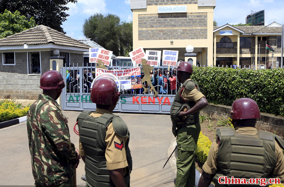 Administration policemen stand outside the gates of Riadha House the Athletic Kenya (AK) Headquarters during a protest in Nairobi, November 23, 2015. Kenyan athletes stormed the athletics federation headquarters in Nairobi on Monday, locking out officials and demanding that top Athletics Kenya (AK) bosses step down following allegations of graft and doping cover-ups. [Photo/China.org.cn]