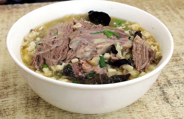 Pita bread in mutton soup is among Xi'an's delicacies. [Photo/China Daily]