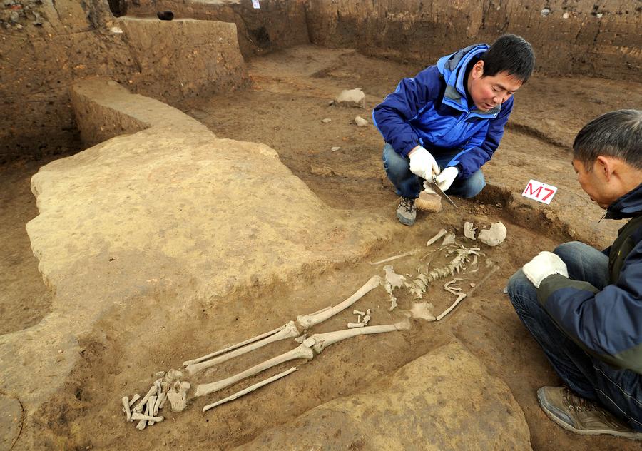 Archaeologists clear a tomb at the excavation site of the Neolithic site at the ruins of the Longgang Temple paleoanthropological site in Hanzhong city of Shaanxi province. [Photo/Xinhua]