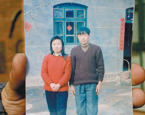 A family member displays a 1993 photo of Nie Shubin with his older sister. Nie was executed in 1995, having been convicted of raping and murdering a 38-year-old woman. Xiao Chen / for China Daily