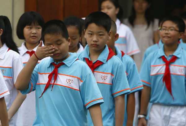 A sleepy student rubs his eyes during a ceremony held to open a new semester at Xiangming Junior High School, in Shanghai, on Sept 1, 2015. [Photo provided to China Daily]