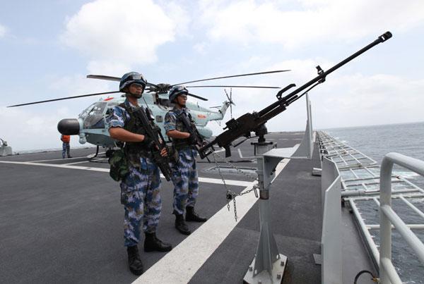 Chinese Navy soldiers observe from China's amphibious landing ship Changbaishan during an escort mission in the Gulf of Aden, Aug 26, 2014. [Photo/Xinhua] 