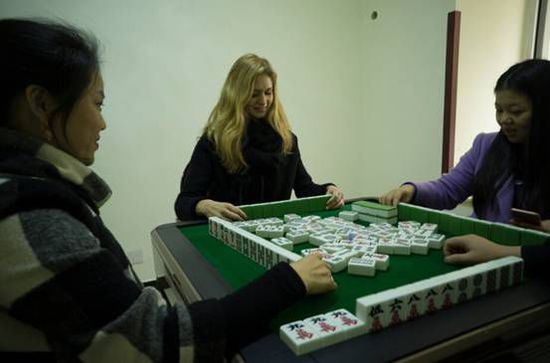 An undated photo shows a Ukrainian girl playing Mahjong with local citizens in Chengdu city in southwest China’s Sichuan province. The girl has become a hit in China’s social media recently. She helps some local migrant workers buy train tickets home for the Spring Festival online. [Photo: People’s Daily Online] 