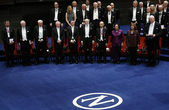 The 2015's Nobel laureates (front row, L to R), Takaaki Kajita and Arthur B. McDonald in Physics, Tomas Lindahl, Paul Modrich and Aziz Sancar in Chemistry, William C. Campbell, Satoshi Omura and Tu Youyou in Physiology or Medicine, Svetlana Alexievich in Literature, and Angus Deaton in Economics, pose for photos following the Nobel Prize award ceremony at the Concert Hall in Stockholm, capital of Sweden, Dec. 10, 2015. [Photo/Xinhua]