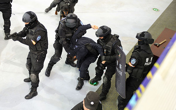 Police seize a simulated gangster during an emergency drill in Urumqi, Xinjiang Uygur autonomous region, earlier this month. The scenario involved a female audience member at a sports event who was kidnapped by two gangsters with knives.[Photo/China Daily]