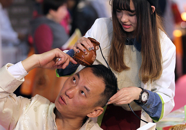 A male customer learns how to use skin care products at an industry expo in Beijing. [Photo/China Daily] 