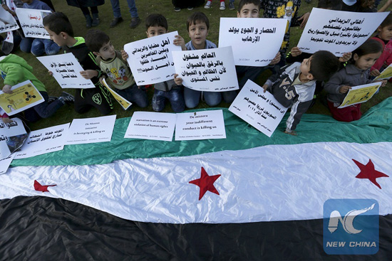 Syrian children carry placards as they call for the lifting of the siege off Madaya and Zabadani towns in Syria, in front of the offices of the U.N. headquarters in Beirut, Lebanon December 26, 2015. [Photo/Xinhua]