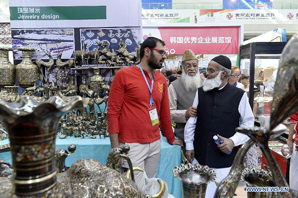 People select Pakistani brassware at the China-Arab States Expo 2015 in Yinchuan, capital of northwest China's Ningxia Hui Autonomous Region, Sept 12, 2015. [Photo/Xinhua]