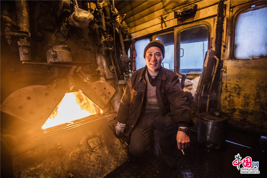 A stoker works in the engine of a steam train in Hami prefecture, Northwest China's Xinjiang Uygur Autonomous Region, Jan 13, 2016. [Photo/China.org.cn]