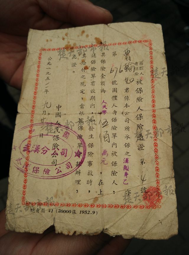 这份中国人民保险公司武汉分公司的人寿保单仅有一张纸，大小不到A4纸的一半，颜色泛黄，边角已出现破损，但上面的字迹内容仍清晰可辨。保单的正面写明，保险人为曹某如，保险金额为500万元，时间为1952年9月23日。