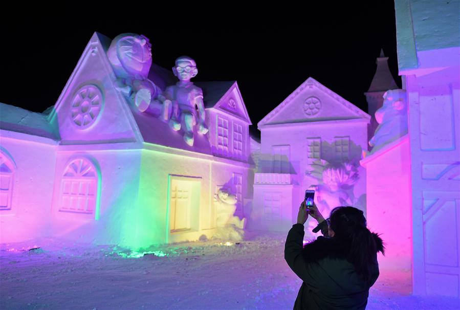  A tourist takes pictures of snow sculptures on Changbai Mountain, northeast China&apos;s Jilin Province, Jan. 15, 2016. 