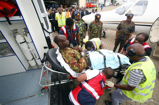 Health workers carry an injured soldier to an ambulence at Wilson Airport in Nairobi, Kenya, on Jan. 17, 2016. The Kenyan government has started evacuating its soldiers injured in the dawn Al-Shabaab terrorist attack at AMISOM base in southern Somalia. [Photo/Xinhua]