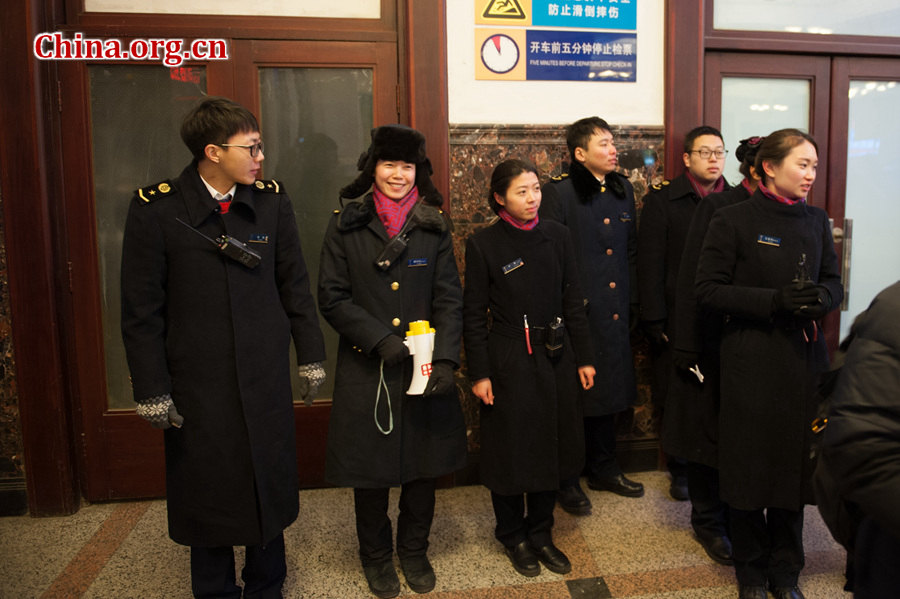 Railway staff members greet passengers at midnight of Jan. 24, the first day of the 40-day-long annual Spring Festival Travel rush at the Beijing Railway Station. [Photo by Chen Boyuan / China.org.cn]