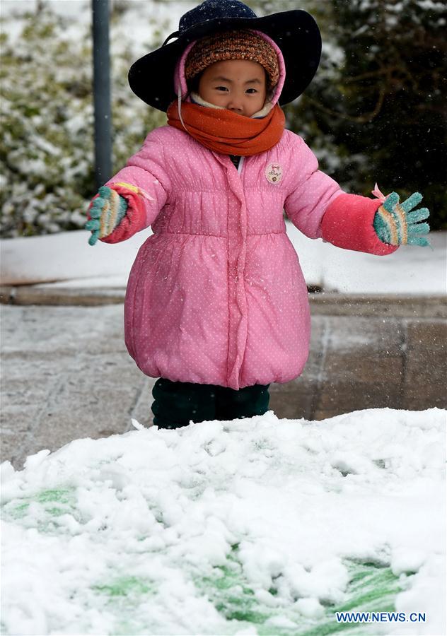 A girl plays with snow by the Dianchi Lake in Kunming, capital of southwest China's Yunnan Province, Jan. 24, 2016. A cold wave and snowfall hit Kunming, known as the Spring City, at this weekend. (Xinhua/Lin Yiguang) 