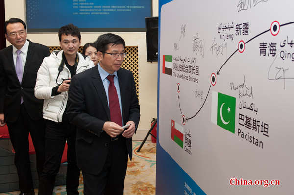 Fan Xianrong, director of the Foreign Affairs Office of Ningxia, sign his name to the signature board at the press conference to promote the 'Friendly tour from China to the Arab states' in Beijing on Jan. 22. [Photo by Chen Boyuan / China.org.cn] 