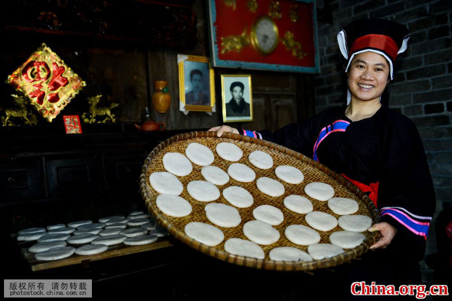 广西贺州市八步区南乡镇，一名壮家妇女展示做好的糍粑。多年来，白糍粑就是南乡壮族节日和喜庆中不可缺少的一种食品。每年除夕前数日，壮乡家家户户就开始张罗做白糍粑了。[中国网图片库 黄旭胡 摄]