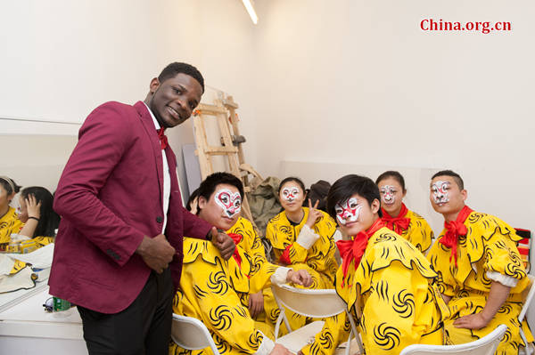 Nathan Diwambuena Miayiza, a DR Congolese student studying in Beijing poses for photos with a group of Peking Opera performers at the 'Beijing Salon – Experience Beijing' on Wednesday. [Photo by Chen Boyuan / China.org.cn]