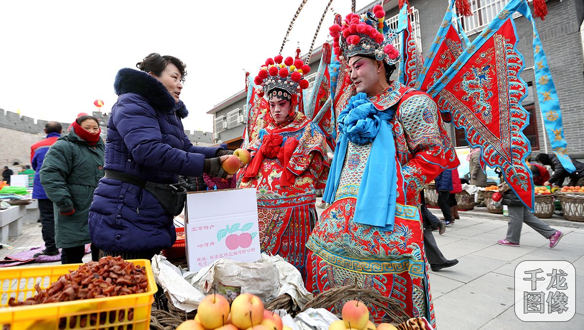 1月30日，第二届河防口古关迎春大集开幕。图为大集上还未卸妆的艺人也加入到采购年货的队伍当中。千龙网记者 王悦摄 (2)