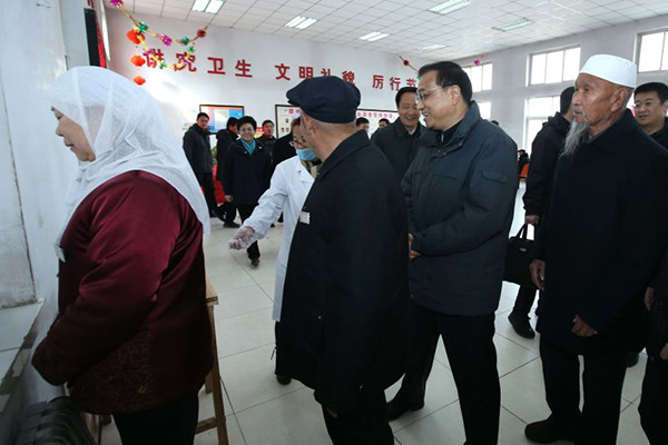 Premier Li waits in line for lunch at a nursing home in Yuanzhou District of Guyuan, Ningxia Hui autonomous region, on Feb 1. [Photo/English.gov.cn] 