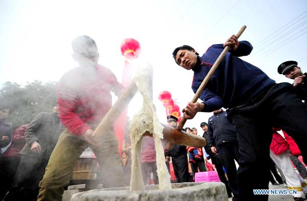 Local people make 'Ciba', a special glutinous rice cake for Chinese Spring Festival, during a folk culture show in Zhangjiajie, central China's Hunan province, Jan 18, 2014. [Photo/Xinhua]