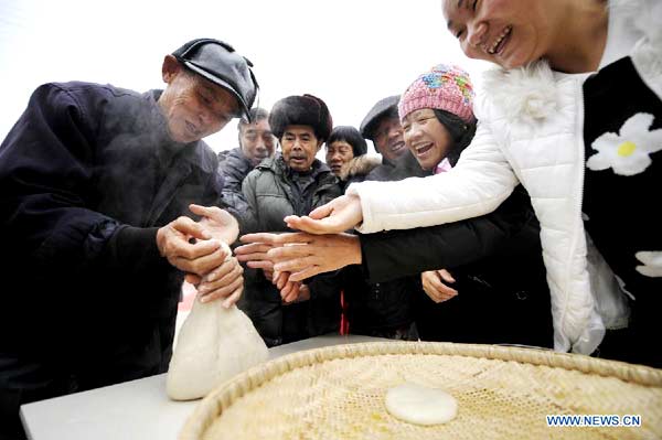 Local people make 'Ciba', a special glutinous rice cake for Chinese Spring Festival, during a folk culture show in Zhangjiajie, central China's Hunan province, Jan 18, 2014. [Photo/Xinhua]