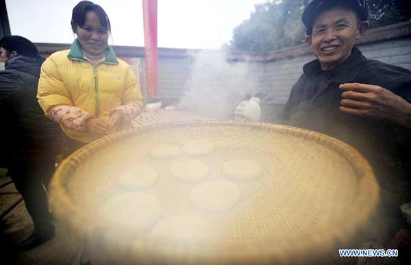 ocal people make 'Ciba', a special glutinous rice cake for Chinese Spring Festival, during a folk culture show in Zhangjiajie, central China's Hunan province, Jan 18, 2014. [Photo/Xinhua] 