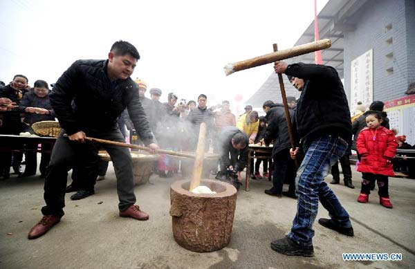 Local people make 'Ciba', a special glutinous rice cake for Chinese Spring Festival, during a folk culture show in Zhangjiajie, central China's Hunan province, Jan 18, 2014. [Photo/Xinhua] 