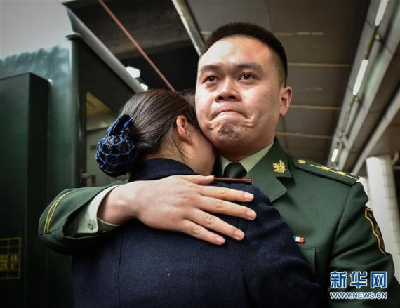 Frontier soldier Pan Ding hugs his wife Lei Yun, a railway attendant at the platform of Guangzhou East Railway Station. [Photo/Xinhua]