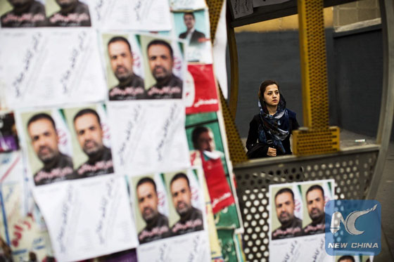 An Iranian woman walks past electoral posters for the upcoming parliamentary elections in downtown Tehran on February 22, 2016. [Photo/Xinhua]