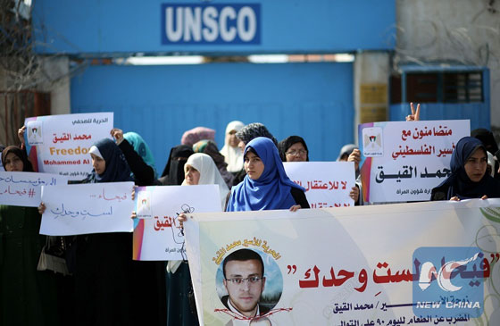 Palestinian women hold posters bearing a portrait of hunger striking Palestinian journalist Mohammed al-Qiq, who is imprisoned in an Israeli jail, during a demonstration in his support in Gaza City on Feb. 21, 2016. [Photo/Xinhua]