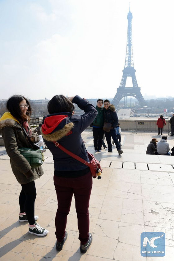 Chinese tourists take souvenir pictures of the Eiffel tower on March 27, 2013 in Paris. [Photo/Xinhua]