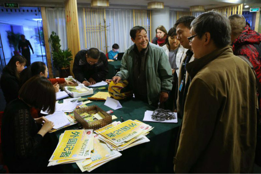 Foreign journalists receive press credentials for the two sessions, at the Media Center Hotel in Beijing, March 1, 2016. [Photo by Kuang Linhua/chinadaily.com.cn]