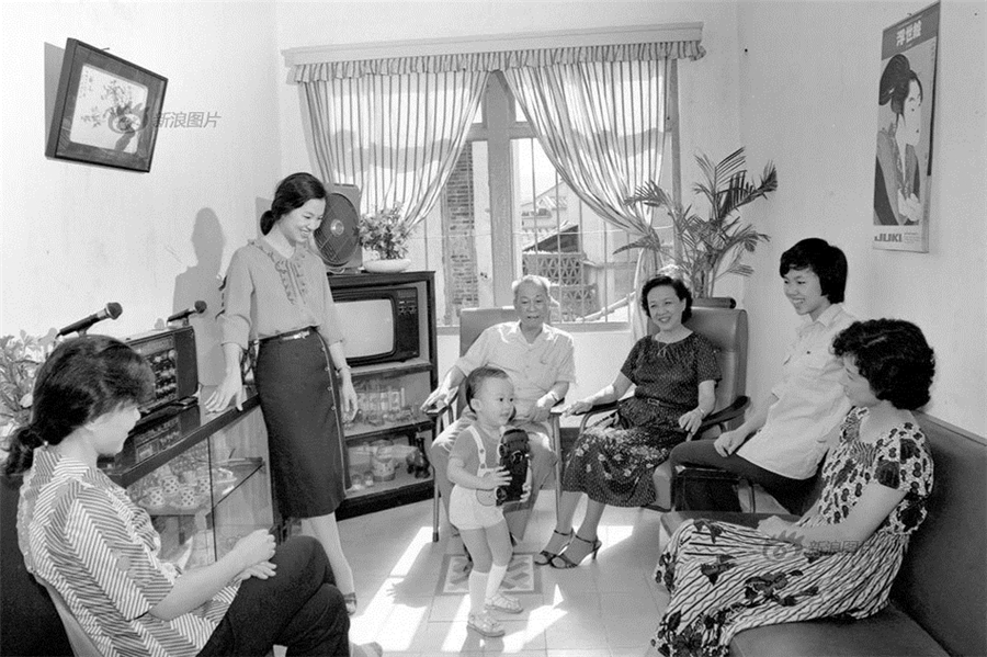 A family in Xiamen, East China's Fujian province, in 1980. They have many of the most common 'modern' necessities of the time, namely sofas, a color television, a radio and an electronic fan. The owner of the house, the senior man, fourth from the right is the vice manager of a company. [Photo/Xinhua]