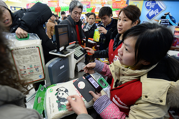 A consumer pays via a digital payment system in a supermaket in Wuhan, capital of Hubei province. [Photo/China Daily]