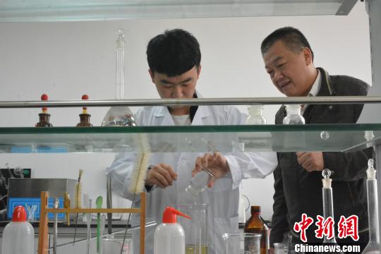Xiong Wanfeng (L), one of the perfume makers, makes perfume at Jiangxi University of Science and Technology. [Photo/Chinanews.com] 