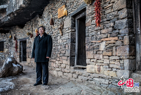 Liu Jiakun poses for a photo shoot as he stands outside the antique and historic homes of Jiujianpeng, which consists of nine houses. [chinagate.cn by Zheng Liang]