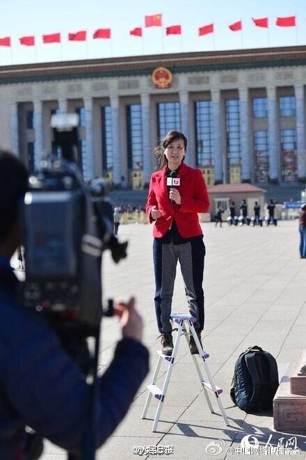 A female reporter standing on a ladder to get a better view of proceedings at the 'Two Sessions' political meetings currently underway in Tian'anmen Square in Beijing, March 8, 2016. [Photo: Weibo]
