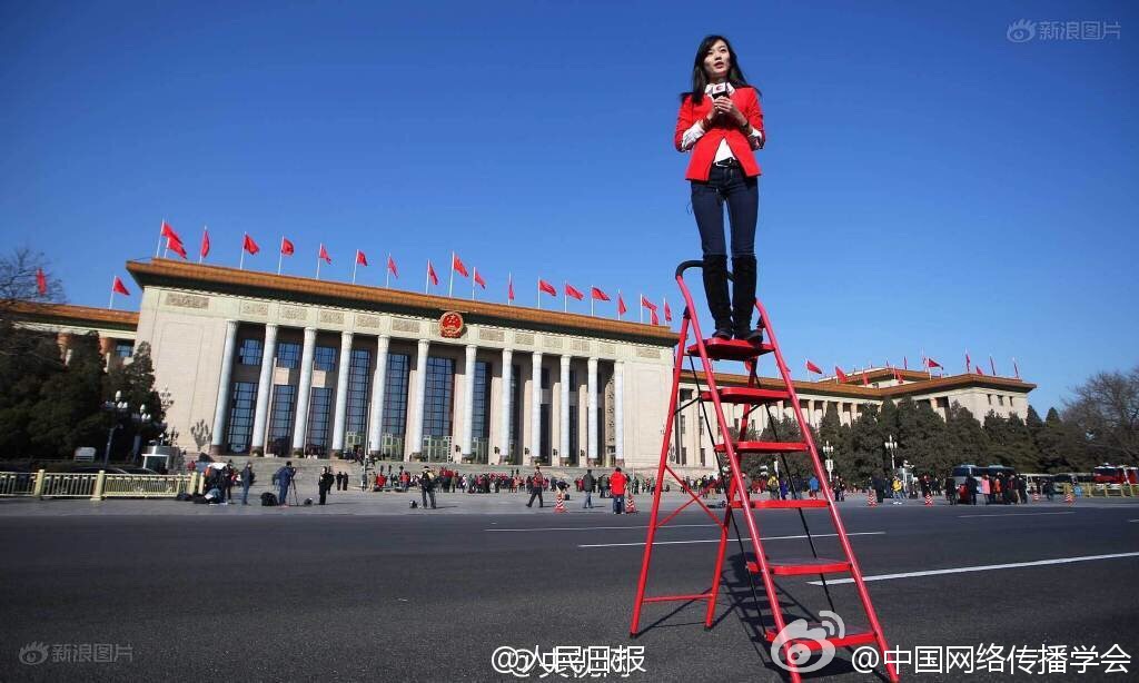 A female reporter standing on a ladder to get a better view of proceedings at the 'Two Sessions' political meetings currently underway in Tian'anmen Square in Beijing, March 8, 2016. [Photo: Weibo] 