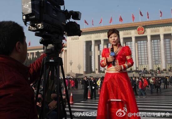 A woman reporter stands on a ladder to cover the fourth annual session of the 12th National People's Congress and the fourth session of the 12th National Committee of the Chinese People's Political Consultative Conference, at Tian'anmen Square in Beijing, capital of China, March 8, 2016. [Photo: Weibo] 