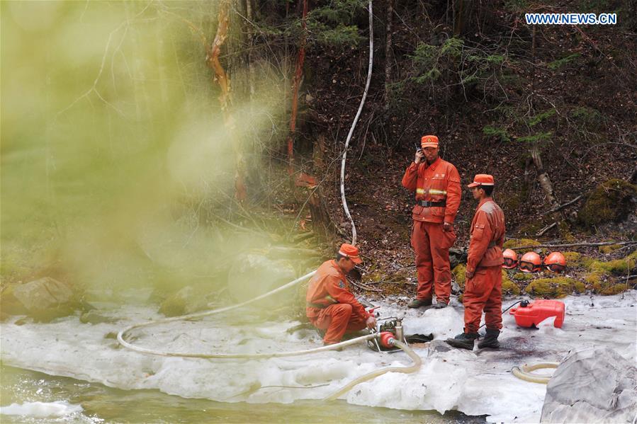 Armed police use a water pump to draw water at a water point in the forest zone of Dala in Tebo County, northwest China's Gansu Province, March 9, 2016. The fire, which was spotted on March 2, has been basically extinguished Wednesday. [Photo/Xinhua]