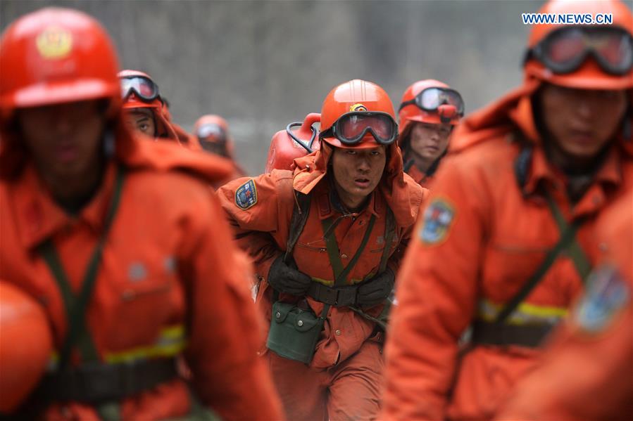 Armed police head to the scene of the fire in the forest zone of Dala in Tebo County, northwest China's Gansu Province, March 9, 2016. The fire, which was spotted on March 2, has been basically extinguished Wednesday. [Photo/Xinhua]