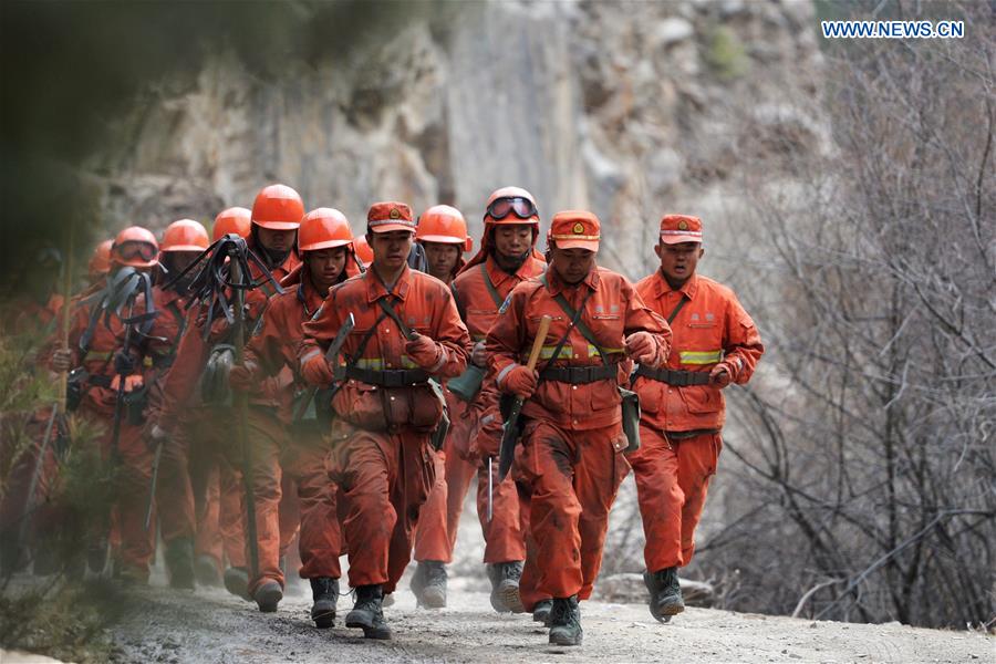 Armed police run to the scene of the fire for clearance work in the forest zone of Dala in Tebo County, northwest China's Gansu Province, March 9, 2016. The fire, which was spotted on March 2, has been basically extinguished Wednesday. [Photo/Xinhua]