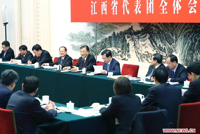 Liu Yunshan (5th L, back), a member of the Standing Committee of the Political Bureau of the Communist Party of China Central Committee, joins a group deliberation of deputies from Jiangxi Province to the annual session of the National People's Congress in Beijing, capital of China, March 13, 2016. (Xinhua/Ding Haitao)