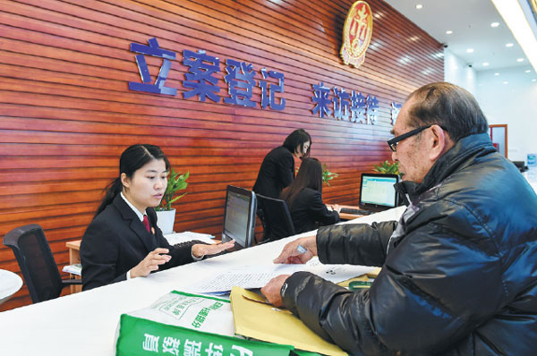 A man applies to file a case with a clerk at the First Circuit Court of the Supreme People's Court in Shenzhen, Guangdong province, on Feb 2, 2015. [Photo/Xinhua]