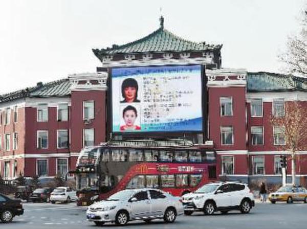 A big LED screen is seen with information of two 'laolai' by the Changchun Road in Changchun, Jilin Province on March 16, 2016. [Photo: news.21cn.com]