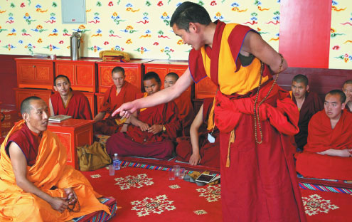 A Tho Ram Pa program student (left) during a debate with a monk from another monastery who was invited to test the candidates. Provided to China Daily